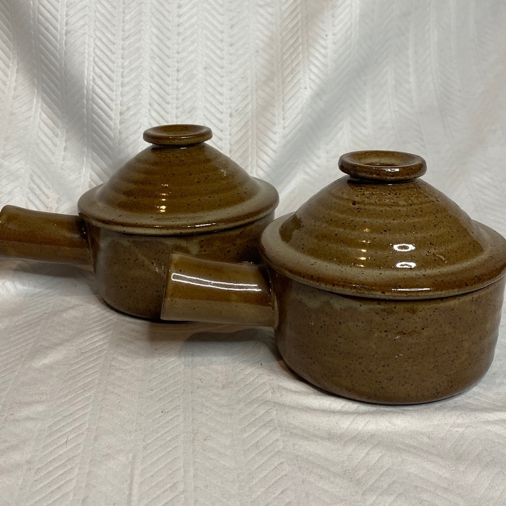 Brown stoneware handled bowl with vented  cover.